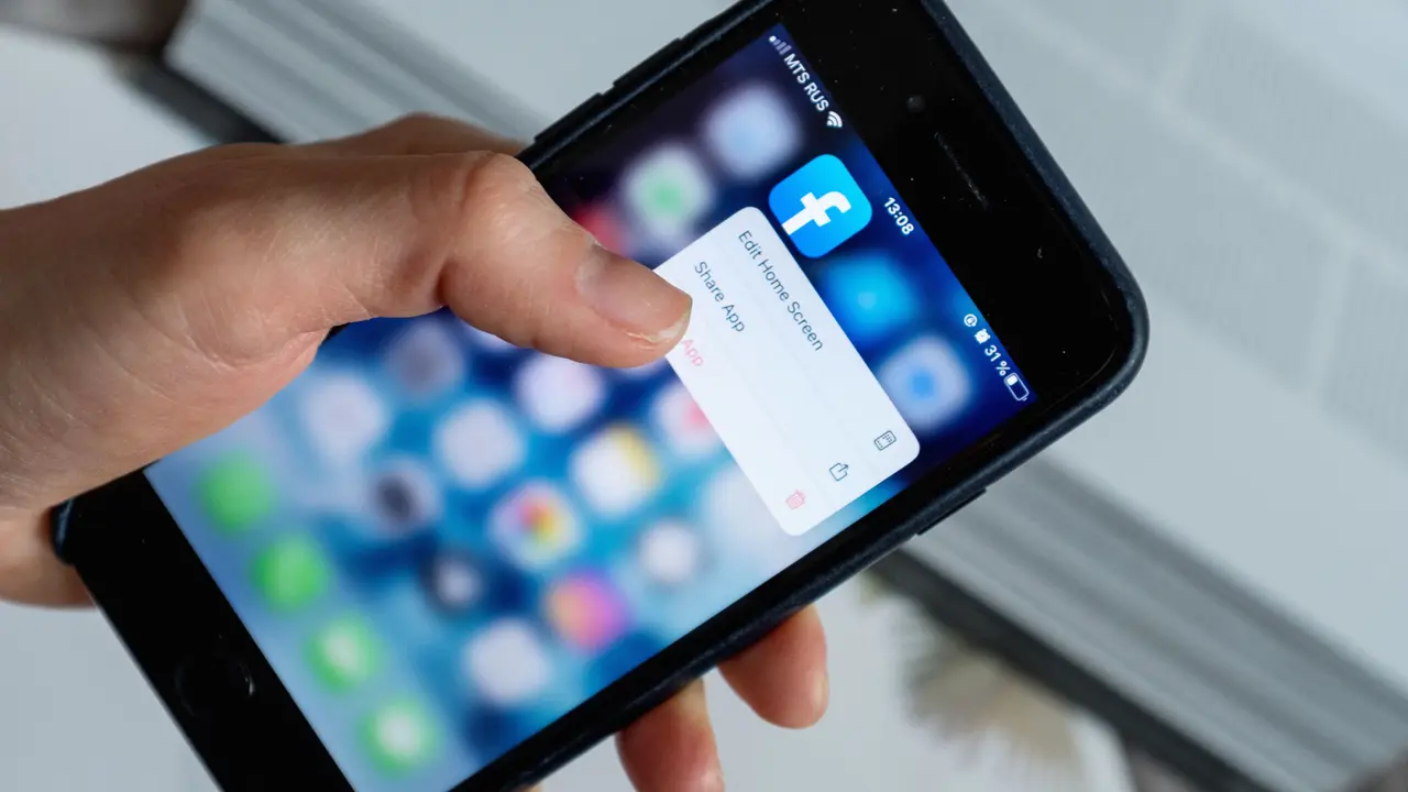 Una mano tocca lo schermo di un telefono e sceglie una voce in una finestra di conferma.
