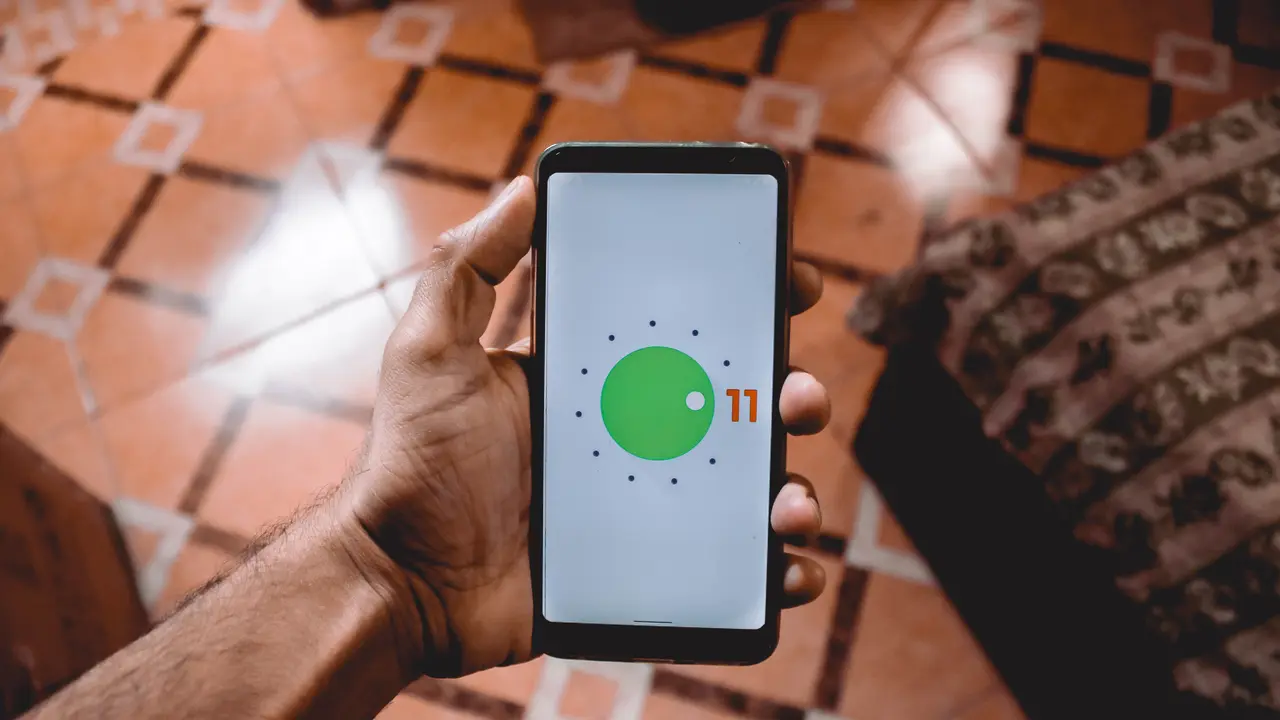 Une main tient un téléphone Android dont l’écran affiche l’interface du système.