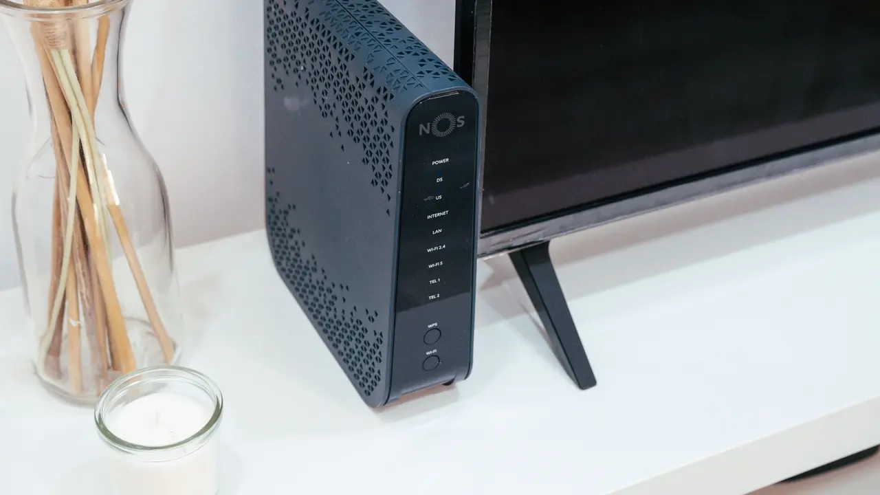 A home internet router standing on a shelf beside a television.