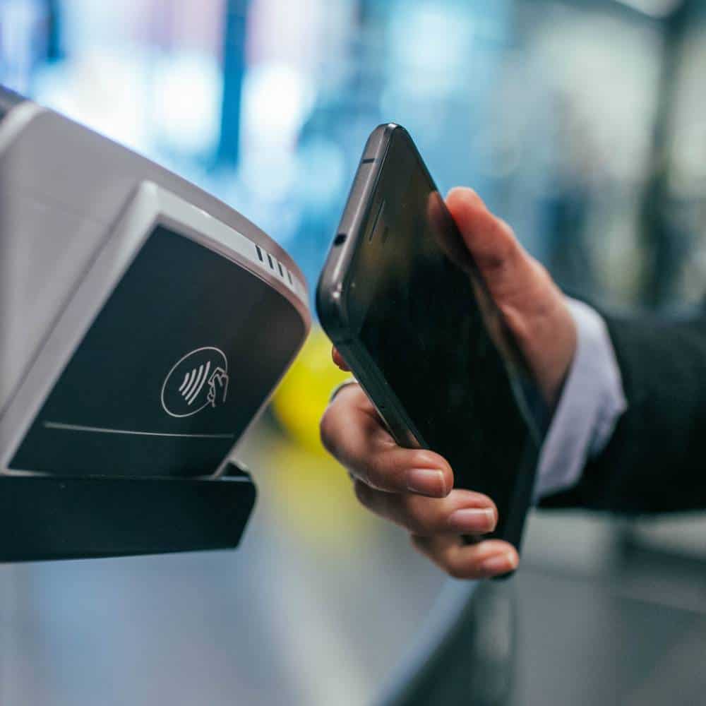 a businessman using his smartphone for a NFC payment
