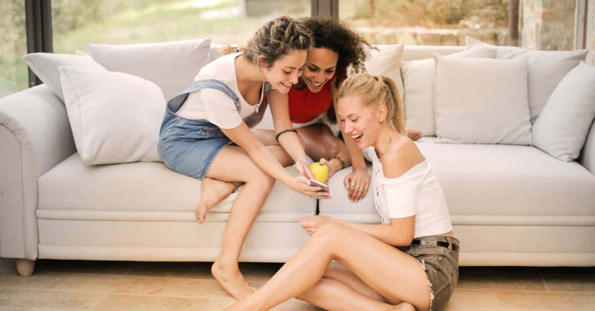 3 woman looking at a phone